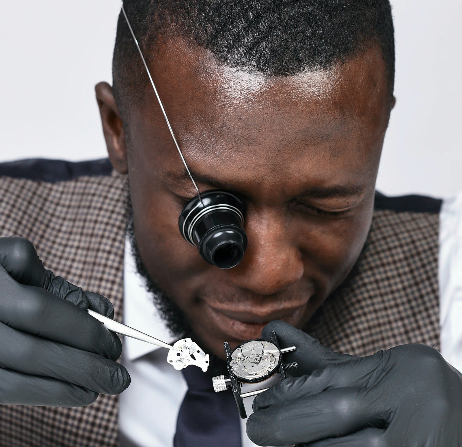 Horloger examinant un mouvement mécanique à la loupe