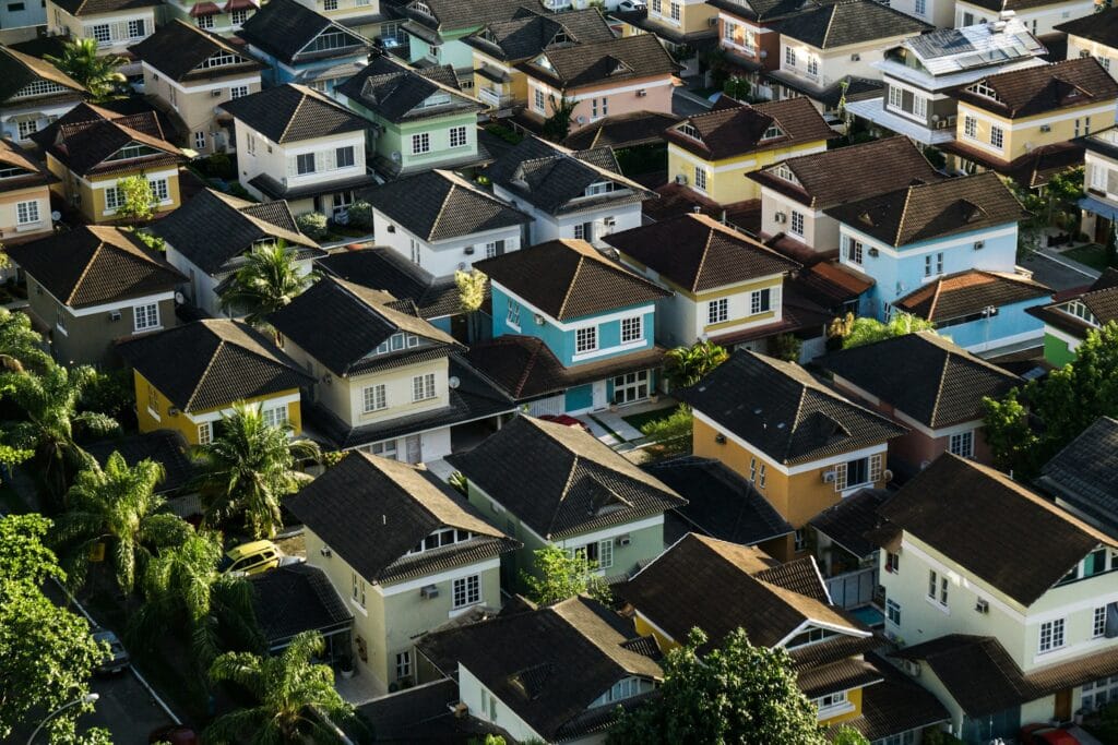 Vue aérienne d’un lotissement résidentiel, toits de tuiles alignés et maisons de couleurs variées